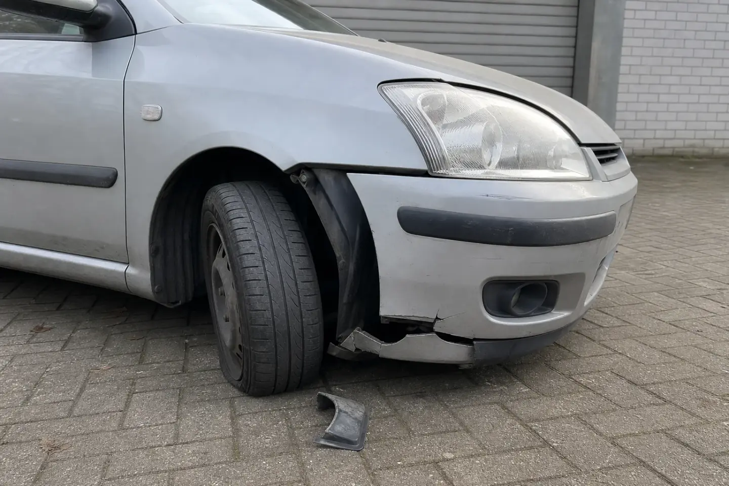 Beispielhafte Verkaufssituation: beschädigtes Vorderrad und gerissene Stoßstange an einem Unfallfahrzeug