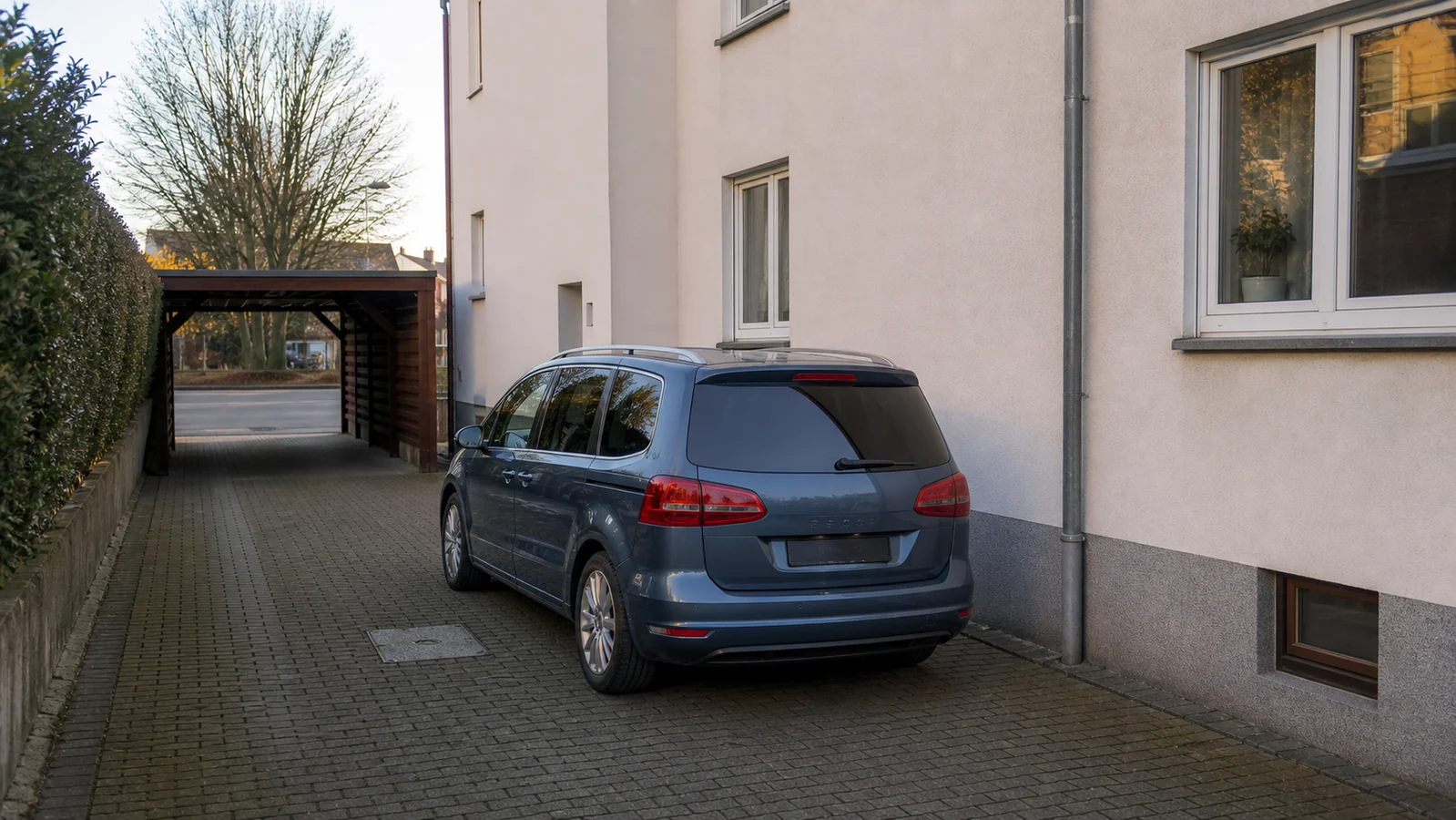 Beispielhafte Verkaufssituation: van in einer schmalen Seitenzufahrt zwischen Hauswand und Hecke in Mülheim-Styrum