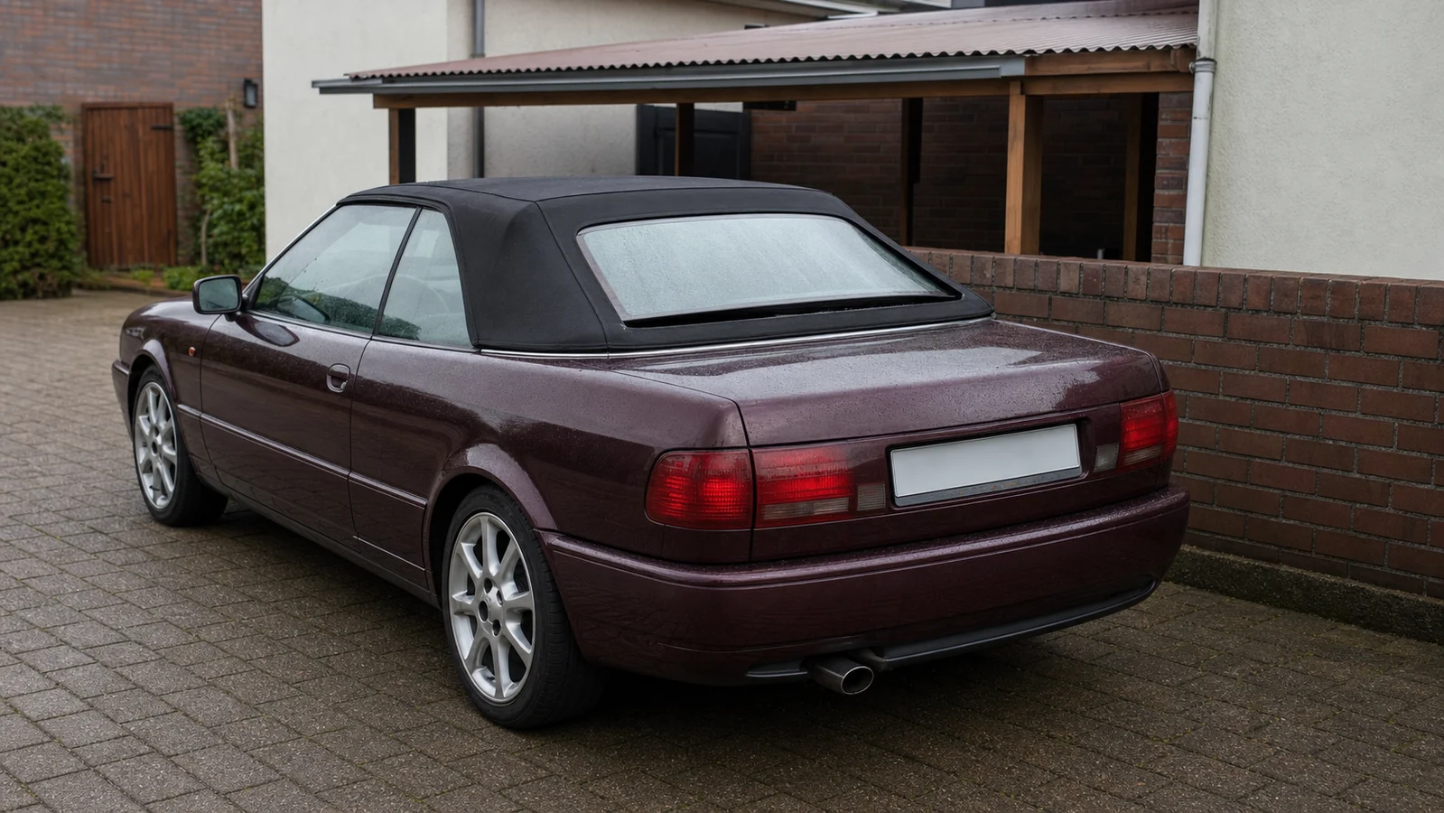 Beispielhafte Verkaufssituation: burgunderfarbenes Cabriolet mit gelöstem Verdeck am Heckfenster in der Stimberg-Siedlung