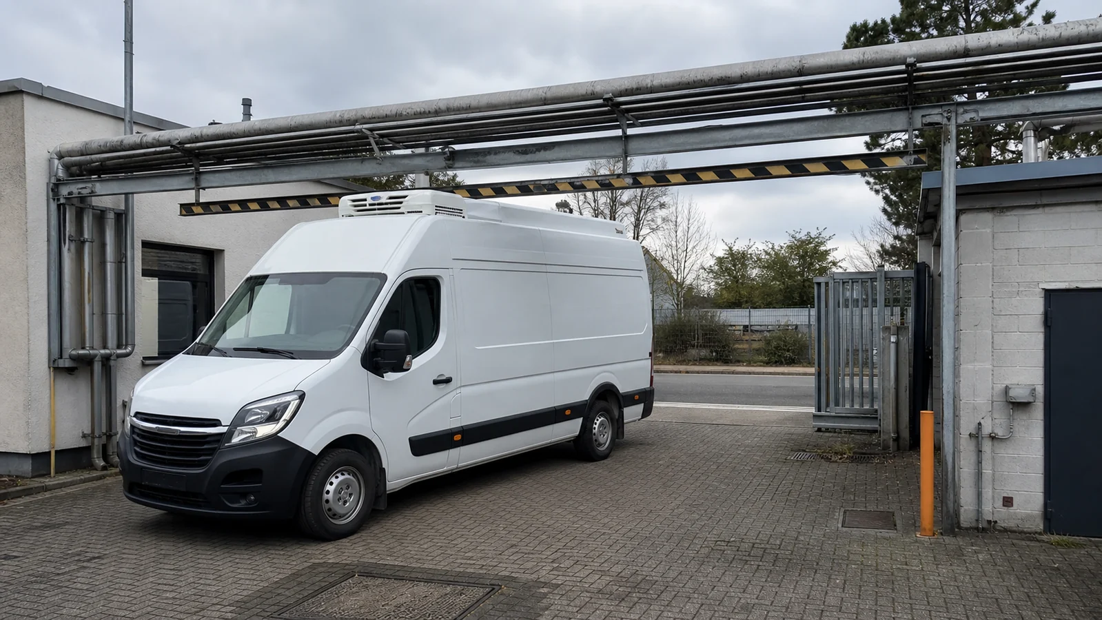Beispielhafte Verkaufssituation: kühltransporter unter einer niedrigen Rohrbrücke auf einem Betriebshof in Schwelm-West